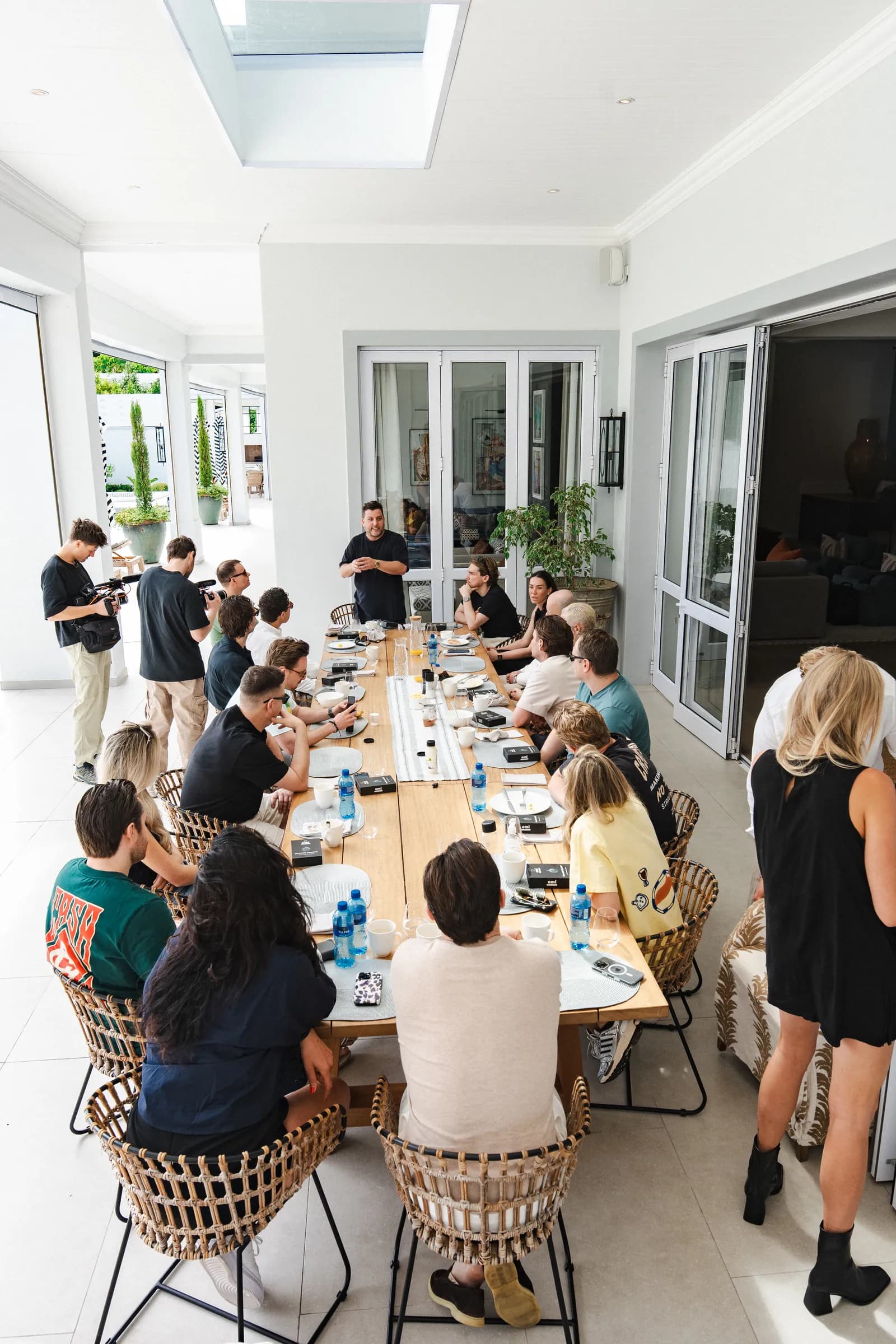 De lange tafel op het terras van de villa, waar de hele groep een idee doorneemt.